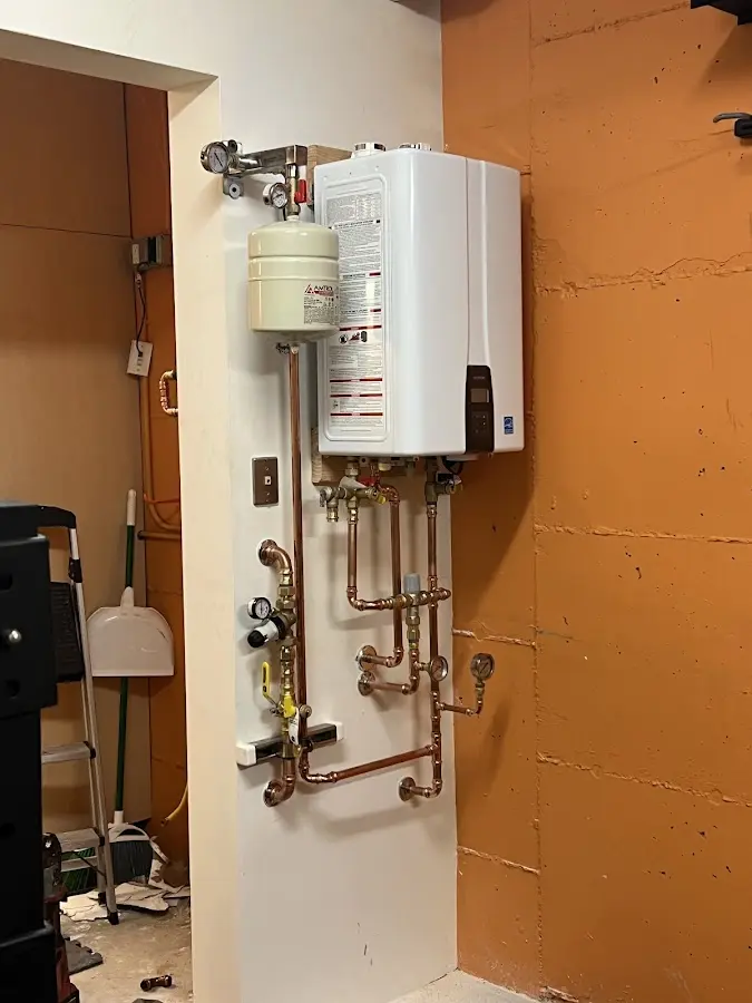 Plumbing technician inspecting water heater connections in New Roads